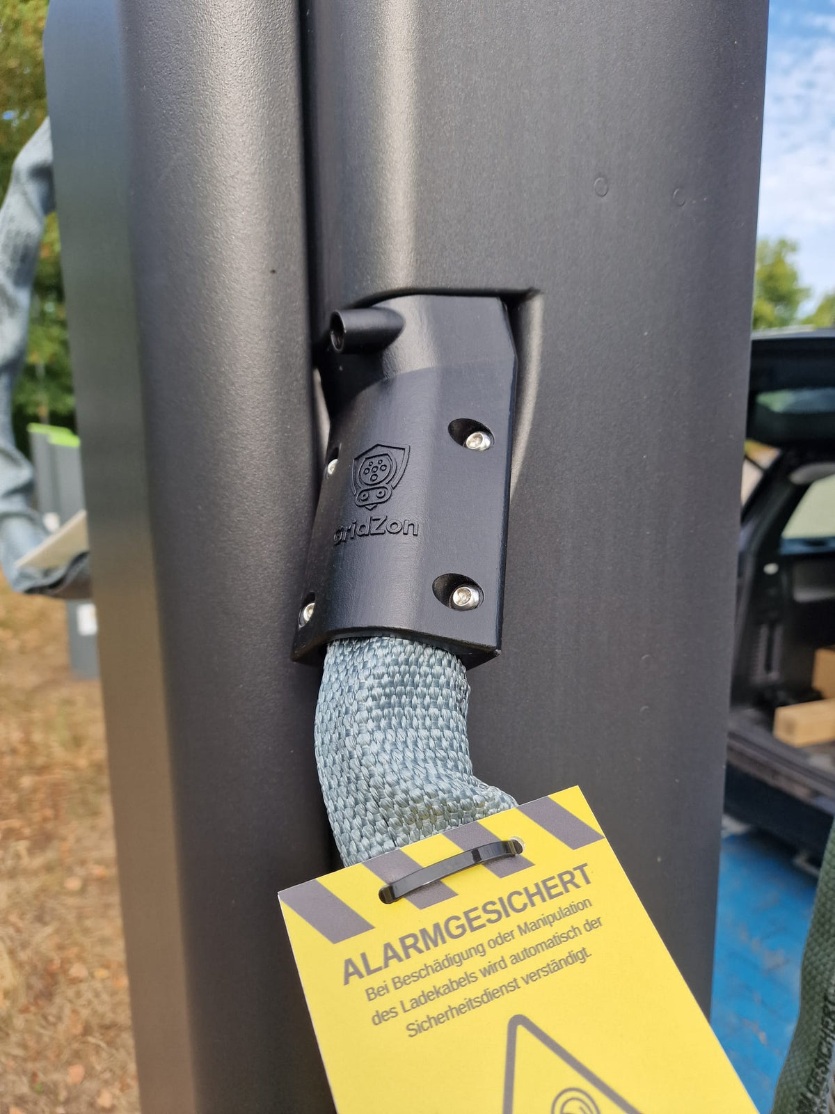 GRIDZON Kabelschutz am Alpitronic HYC 50 – Beschlag mit Warnhinweis